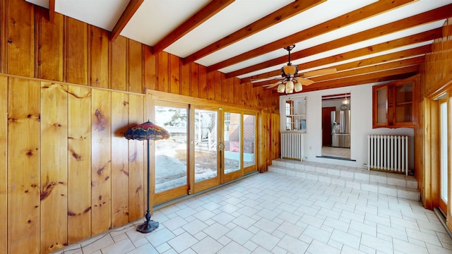 unfurnished sunroom featuring beam ceiling, french doors, radiator heating unit, and ceiling fan