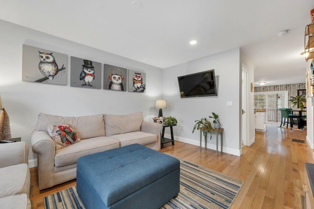 living area with recessed lighting, light wood-type flooring, and baseboards