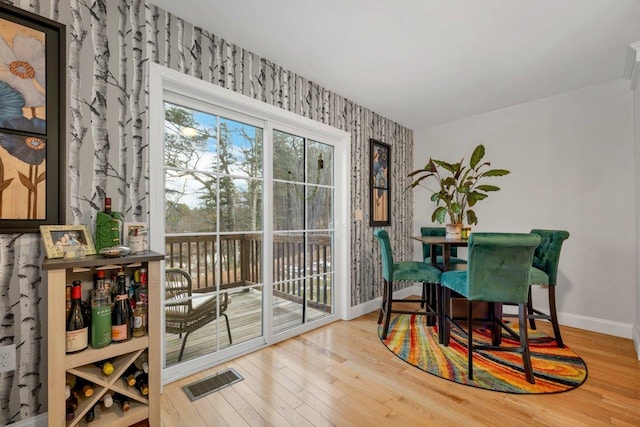 dining area featuring wood finished floors, visible vents, and baseboards