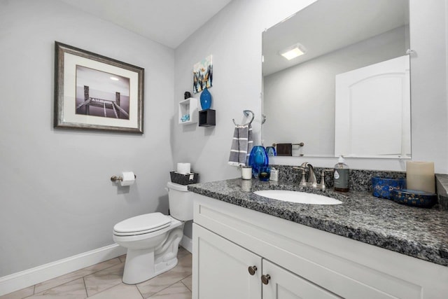 half bath with baseboards, toilet, marble finish floor, and vanity