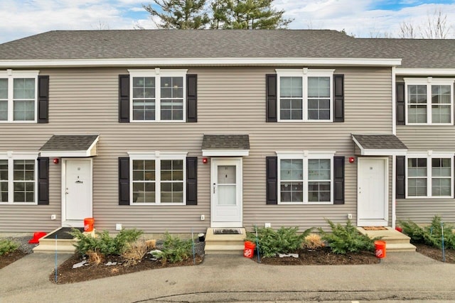 townhome / multi-family property featuring roof with shingles