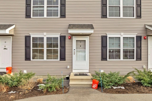 property entrance with a shingled roof