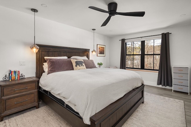 bedroom featuring light wood-style flooring, baseboards, and a ceiling fan