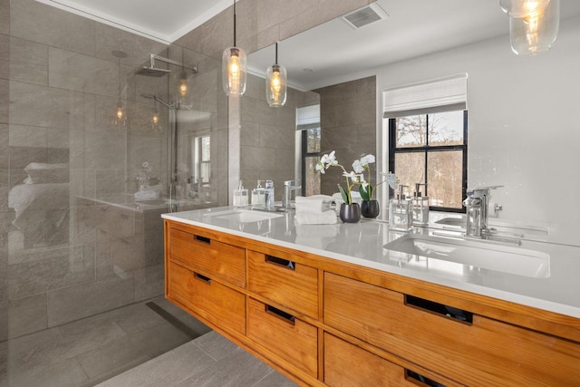 bathroom with visible vents, a sink, tile walls, tile patterned flooring, and walk in shower