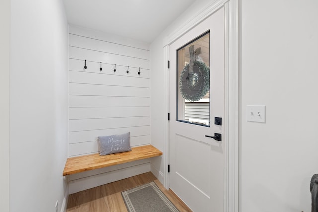 mudroom featuring wooden walls, wood finished floors, and baseboards