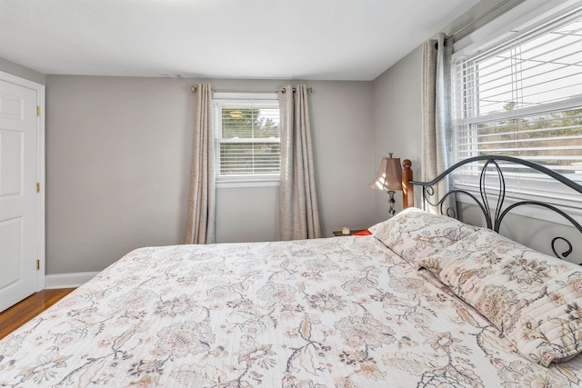 bedroom with wood finished floors and baseboards