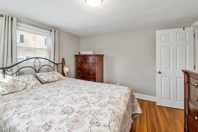 bedroom featuring baseboards and wood finished floors