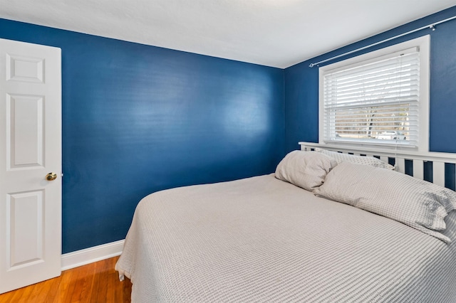 bedroom with baseboards and wood finished floors