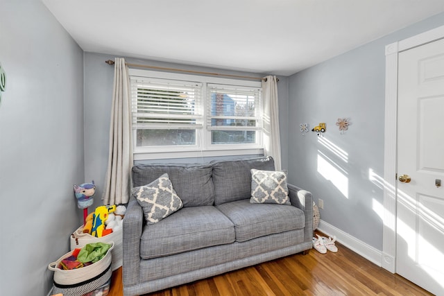 sitting room with baseboards and wood finished floors