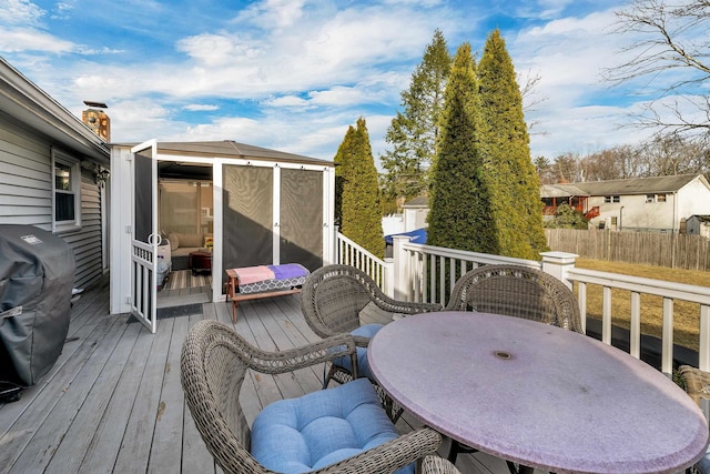 wooden terrace featuring outdoor dining area and area for grilling