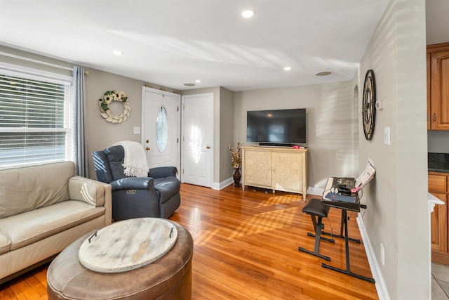 living area featuring recessed lighting, baseboards, and light wood-style floors