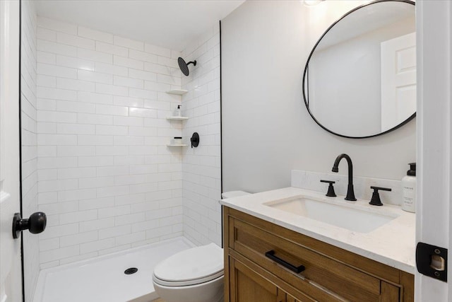 bathroom with toilet, a stall shower, and vanity