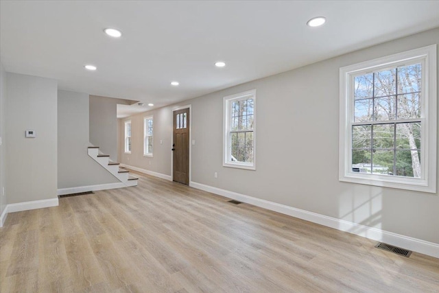 foyer with visible vents, recessed lighting, light wood-style floors, baseboards, and a healthy amount of sunlight