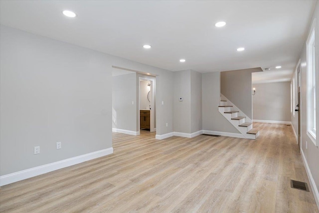 interior space with light wood finished floors, visible vents, recessed lighting, and stairs