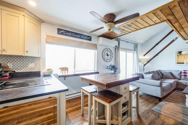 kitchen featuring decorative backsplash, a wall unit AC, dark countertops, and dark wood-style flooring