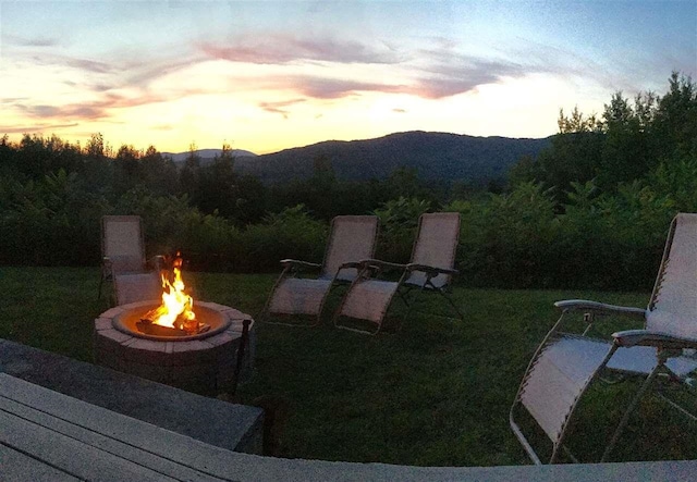 view of yard featuring a mountain view and an outdoor fire pit