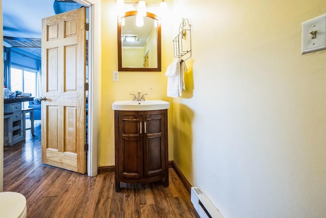 bathroom featuring vanity, wood finished floors, and baseboards