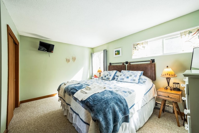 bedroom with light colored carpet, baseboards, and a baseboard radiator