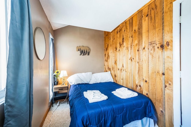 carpeted bedroom with wooden walls