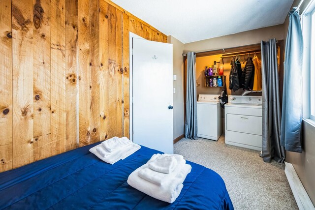 bedroom with a closet, wooden walls, and washing machine and dryer