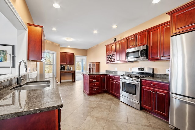 kitchen with a peninsula, recessed lighting, a sink, dark brown cabinets, and appliances with stainless steel finishes