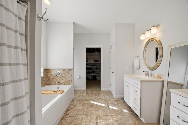 bathroom with a spacious closet, baseboards, a garden tub, a shower with curtain, and vanity