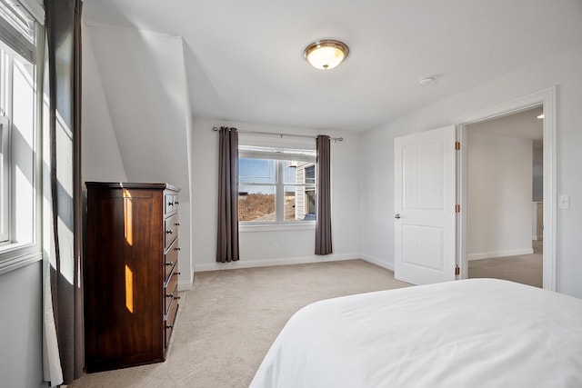 bedroom with baseboards and light carpet