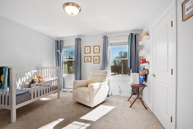 carpeted bedroom with a crib, baseboards, and a baseboard radiator