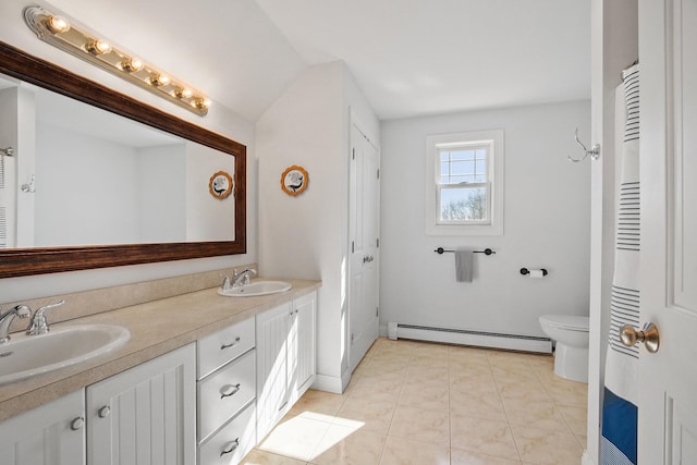 full bathroom featuring double vanity, toilet, a baseboard heating unit, and a sink