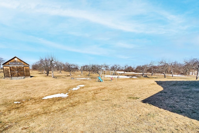 view of yard with playground community and an outdoor structure