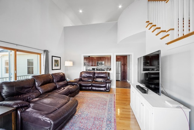 living area with a high ceiling and light wood finished floors