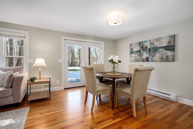 dining space featuring french doors, light wood-type flooring, and a wealth of natural light