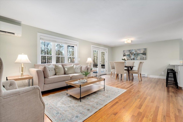 living room featuring light wood-style flooring, french doors, an AC wall unit, and baseboards