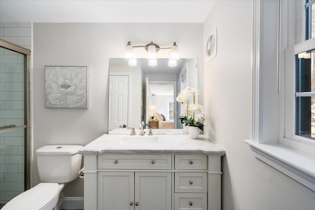 ensuite bathroom featuring tiled shower, toilet, ensuite bath, and vanity