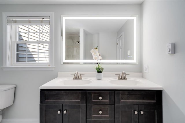 full bath with double vanity, toilet, a shower, and a sink