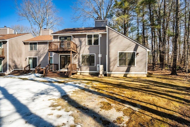 rear view of property featuring a balcony and a chimney