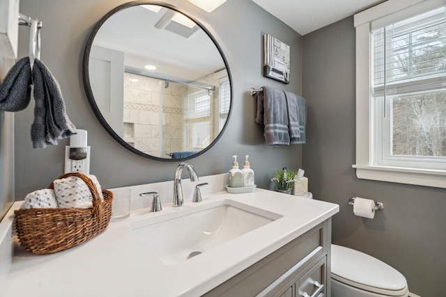 bathroom featuring vanity, toilet, a healthy amount of sunlight, and visible vents