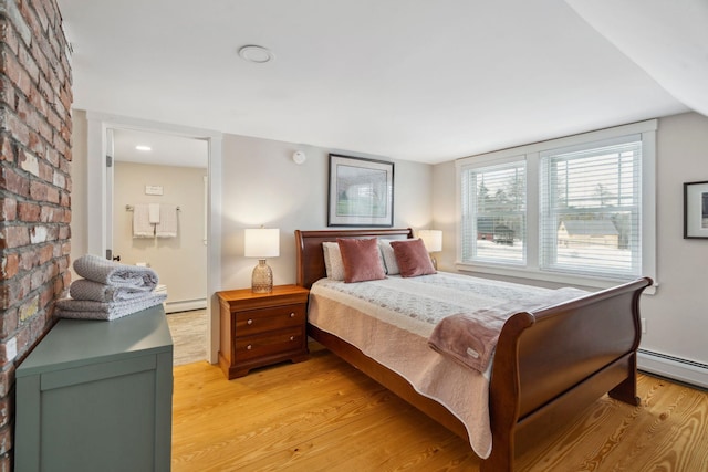 bedroom with a baseboard heating unit, light wood-type flooring, and a baseboard radiator