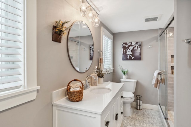 bathroom featuring visible vents, toilet, a shower stall, baseboards, and vanity