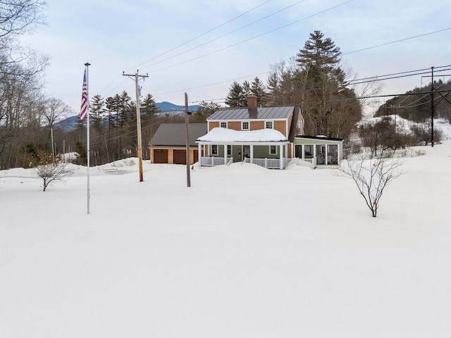 snowy yard featuring a garage and a sunroom