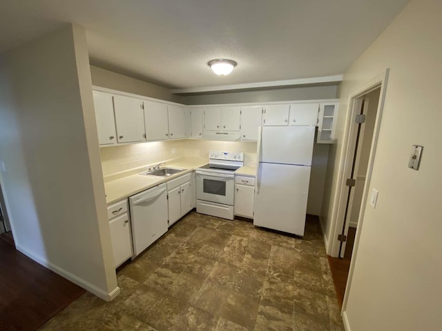 kitchen with under cabinet range hood, light countertops, white appliances, white cabinetry, and a sink