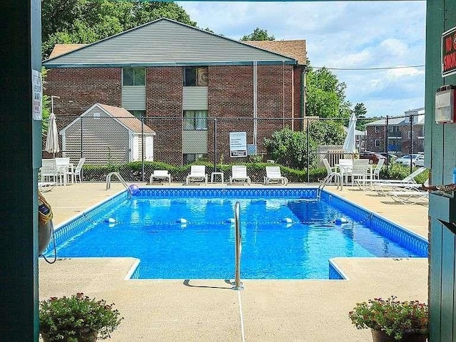 community pool featuring a patio and fence