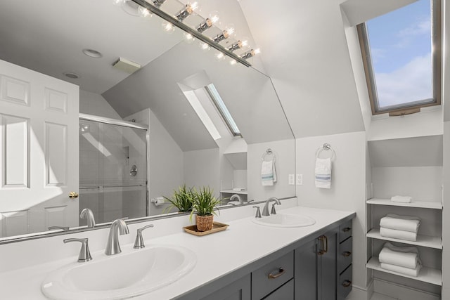 bathroom with a sink, vaulted ceiling with skylight, double vanity, and a shower stall