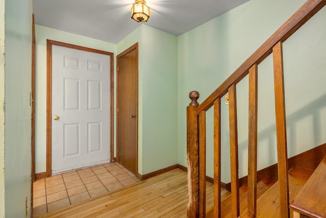 foyer entrance with stairs, baseboards, and light wood-type flooring