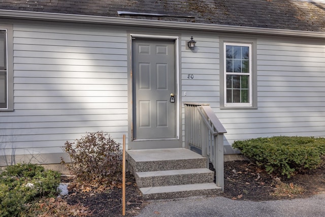 entrance to property featuring a shingled roof