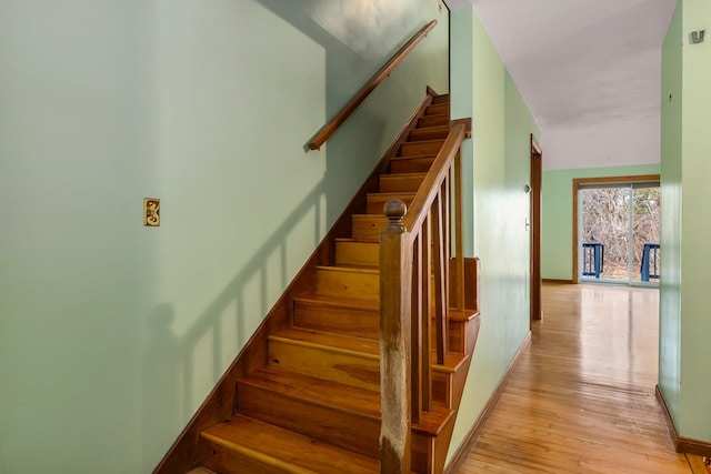 staircase with wood finished floors and baseboards