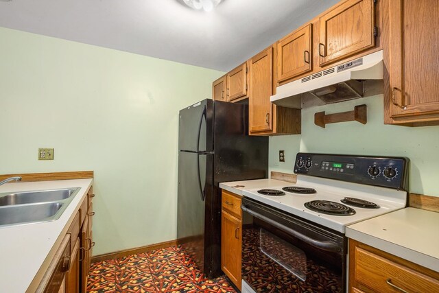 kitchen featuring under cabinet range hood, range with electric stovetop, light countertops, and a sink