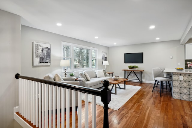 living room featuring recessed lighting, baseboards, and hardwood / wood-style floors