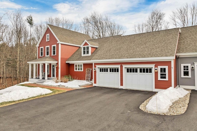 view of front of property featuring aphalt driveway, an attached garage, and roof with shingles