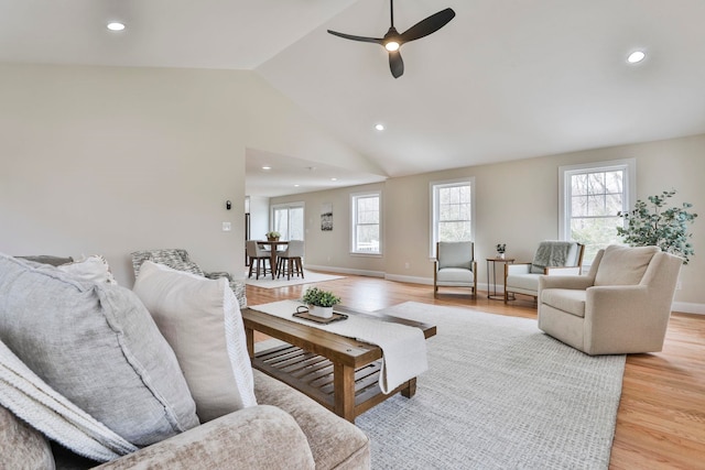 living area with baseboards, lofted ceiling, recessed lighting, ceiling fan, and light wood-style floors